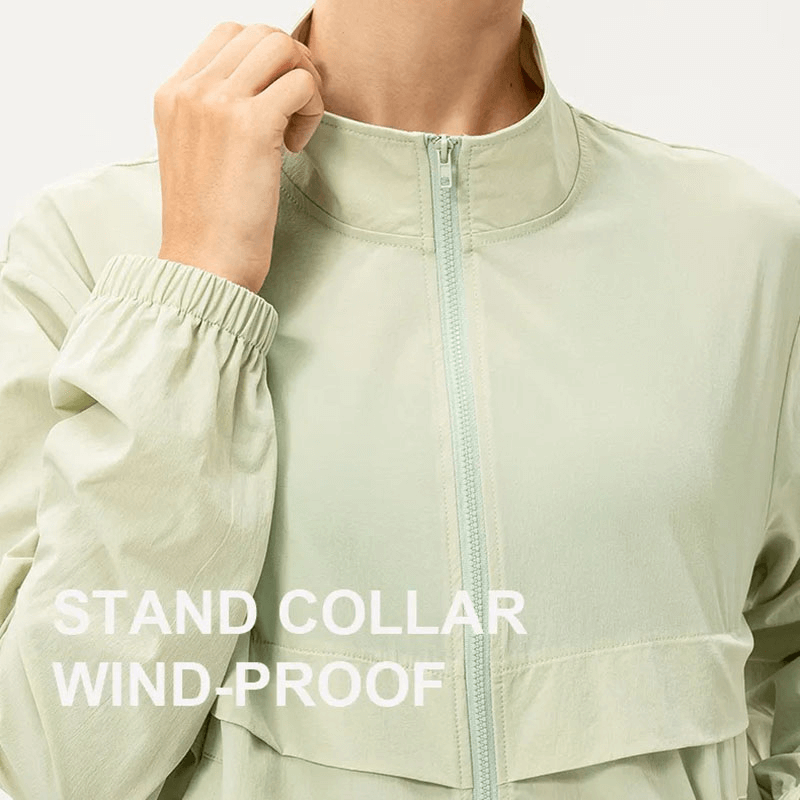 Woman wearing a light green windbreaker with stand collar, windproof design, ideal for running and UV protection.